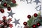 Decorative green frosty pine branches with cones and red shiny and matte balls, red snowflake with red berries, silver stars and