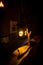 Decorative handcrafted wooden lantern with a candle inside dimly glowing in the dark