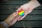 Decorative Heart with rainbow stripes in male hands. LGBT pride flag, symbol of lesbian, gay, bisexual, transgender for social