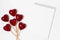 Decorative hearts on sticks and notepad on a white background