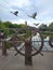 Decorative helm of a ship on a bridge in a park. Decorative metal flying cranes