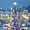 Decorative illuminated Christmas trees in the square of town, bokeh lights, abstract background