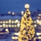 Decorative illuminated Christmas trees in the  square of town, bokeh lights, holiday background