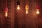 Decorative incandescent bulbs glow on the background of a wall with an ornament