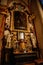 Decorative interior of church St. Henry and St. Kunhuty, gilded ornamented baroque altar, white flowers, tall candles, marble