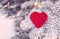 Decorative knitting heart on fir-tree branch. Winter holidays concept. Love concept background. February 14. Textile red heart on