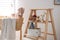 Decorative ladder with toys and different stuff in stylish baby room. Idea for interior design