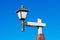 Decorative lamp post with lantern head and white glass on wooden pole and brick base