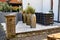 Decorative landscape. Several ceramic vases with plants on white stones in front of a house in Germany