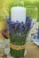 Decorative Lavender Glass, with Lavender Flowers with Candle on a table and Green Blured Summer Bakground.