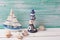 Decorative lighthouse, sailing boat and marine items on wooden