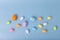 decorative multicolored eggs are scattered on a light blue background, top view