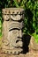 Decorative native american wooden head or totem, propably Aztec or Mayan, displayed on stone pedestal