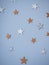 Decorative pastel stars on the wall. Close-up of decorative handmade paper stars of different size on plain blue wall