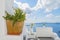 Decorative plants and elements of street design in mediteranian style, and Therasia on backdrop. Santorini island