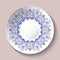 Decorative plate decorated with blue ethnic ornament with hearts in the style of porcelain painting.