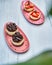 Decorative plates of chocolate and strawberry cakes seen through blurred plants