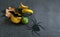 Decorative pumpkins, dry leaves and black spider with bat on the dark gloomy halloween background