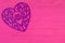 Decorative purple filigree heart on pink