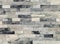 Decorative quartzite cladding wall made of shiny small bricks. Colors are black, gray and white.