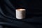 Decorative scented candle burns against black fabric