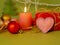 Decorative seasonal composition of a burning candle, felt hearts, Christmas-tree balls, Christmas decor, romantic interior