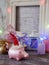 Decorative seasonal composition of a New Year`s pig toy in a red Santa hat, festive illumination, candles