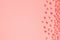 Decorative shiny ribbon with bow on pastel pink background with copy space for text, coral toned Top view, Template