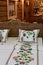 Decorative Slovak embroidery on pillows and bed sheet with floral ornaments, placed on carved wooden bed in Slovak wooden cottage