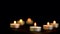Decorative small candles burn on a dark background. Rest and peace, without wind