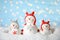 Decorative snowmen on artificial snow against blurred festive lights