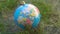 Decorative sphere world bauble on grass.