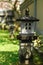 Decorative stone lantern in the form of a house in the yard, on a background of green grass