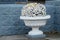 Decorative stone vase with flowers on a granite staircase close-up outdoors