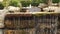 Decorative stone waterfall with falling trickles of clear water and a fountain in the background.