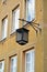 The decorative street lamp on a building wall. Warsaw, Poland