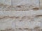 Decorative wall, built of hewn stone slabs of beige color