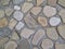Decorative wall paved with flat round shape sea stones almost completely submerged in the cement