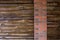 Decorative wall of pine boards painted with varnish. Wood texture. Brick column.