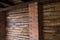 Decorative wall of pine boards painted with varnish. Wood texture. Brick column.