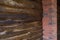 Decorative wall of pine boards painted with varnish. Wood texture. Brick column.