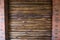 Decorative wall of pine boards painted with varnish. Wood texture. Brick column.