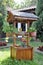 decorative water wood well fountain in the courtyard on a background of green arborvitae. the best choice for