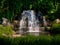 Decorative waterfall in a park with leaves of wild grapes