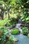 Decorative waterfall in tropical garden, Asia. Ornamental garden with exotical plants and pond