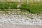 Decorative weathered old wall by the sea in Normandy, stone in part concrete, section, with algae and moss, copy space, space for