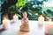 Decorative white Buddha statuette with candles and green monstera plant on the background. Meditation and relaxation