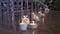 Decorative white bulk candles with wicks in transparent glass flasks.