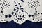 DECORATIVE WHITE PAPER DOILY ON BLUE CLOTH BACKGROUND