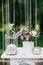 Decorative white vintage table for the wedding ceremony, decorated with a candle in a cage with a bouquet of flowers